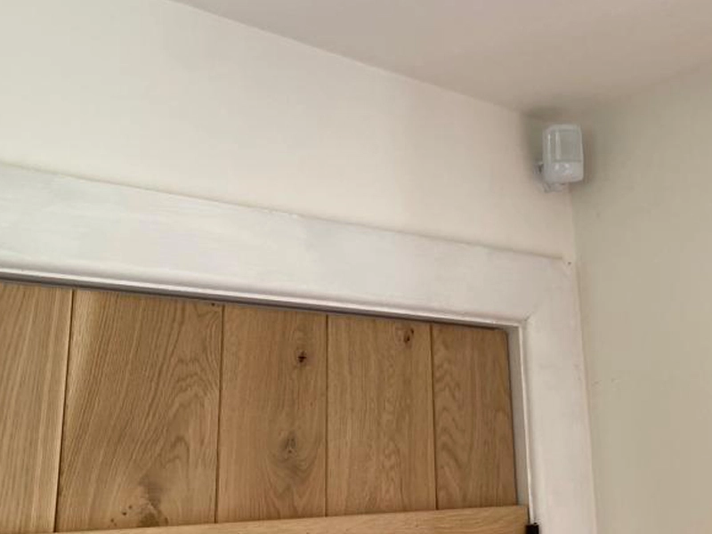 Honeywell Alarm PIR Sensor Mounted On A Wall Inside A House